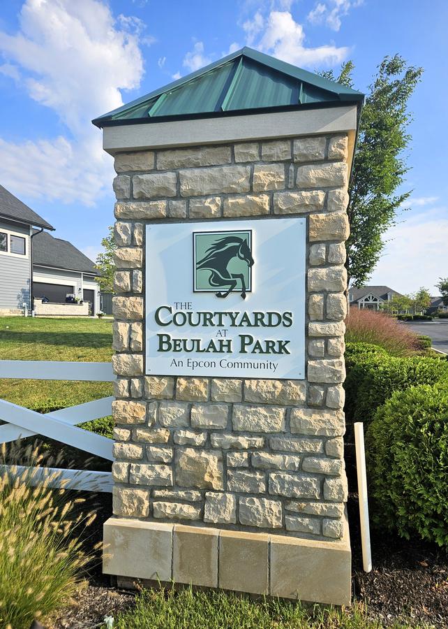 The Courtyards at Beulah Park entrance sign with a horse emblem on a stone tower