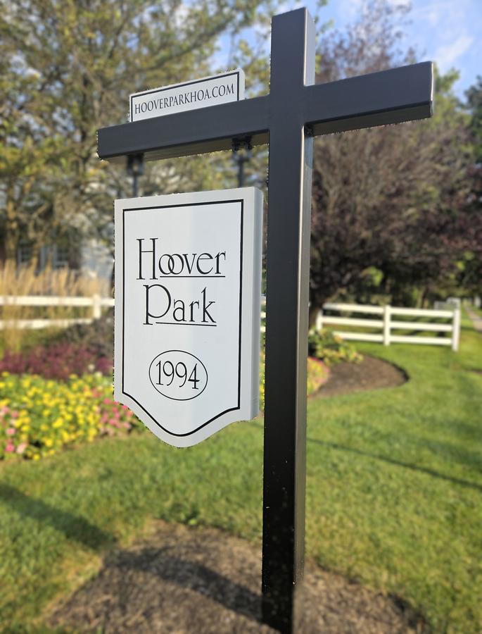 Hoover Park hanging sign dated 1994, with a white fence behind it